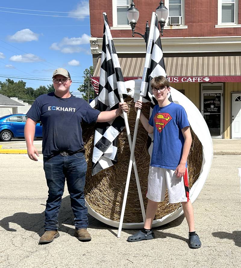 Sawyer Marceau of Polo (left) and Zakkary West of Mt. Morris pose with the large round straw bale they pushed down Wesley Avenue and across the finish line first during the Straw Bale Race at Strawfest on Saturday, Aug. 23, 2025. The 17-year-olds won the event with the fastest time of 9.36 seconds.