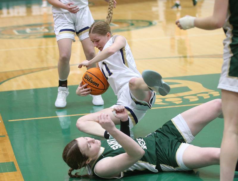 Marquette's Keely Nelson falls in the lane as she is fouled by St. Bede's Lili McClain during the Class 1A Regional semifinal game on Tuesday, Feb. 18, 2025 at St. Bede Academy.
