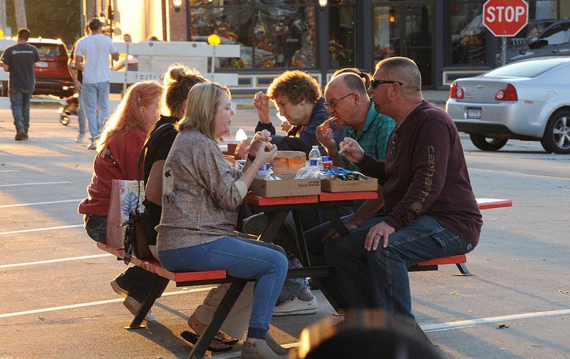 As the evening sun sets, a table full of patrons sample food during the Taste of Sandwich, Wednesday, Sept. 25, 2024, in downtown Sandwich.