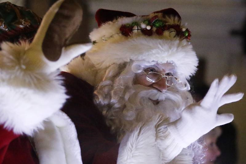 Santa and Mrs. Claus wave to children as they pass by during the annual Festival of Lights Parade on Friday, Nov. 26, 2021, in downtown Crystal Lake.