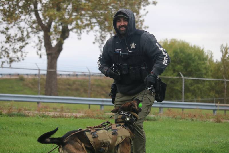 DeKalb police Sgt. Steve Parsons (left) is seen celebrating with Chase Oct. 22, 2025,   after a successful training sequence outside the former GE plant in DeKalb.