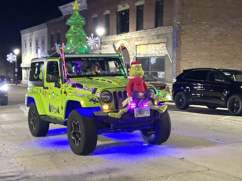 A Jeep decorated for "Grinchmas" travels down Wesley Ave. in the lighted parade during Mt. Morris' Christmas in the Village on Saturday, Dec. 7, 2024.