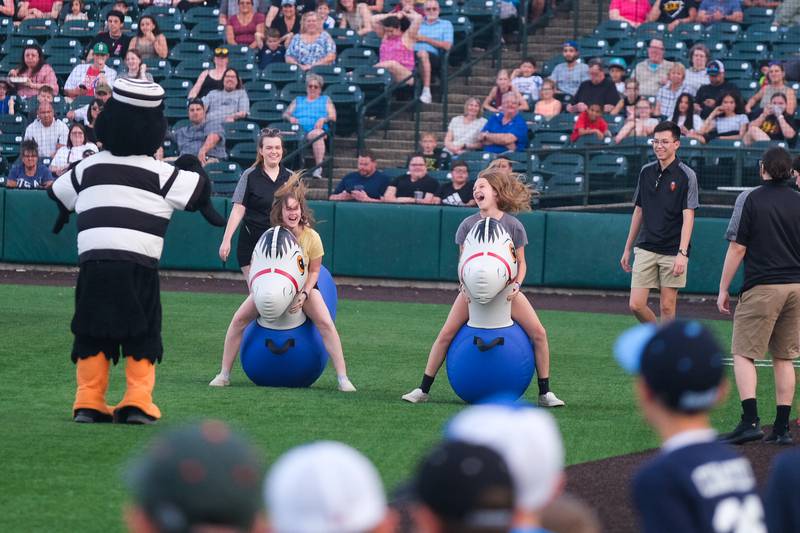 Fans compete in an inflatable horse race between innings at the Joliet Slammers home opener  against the Ottawa Titans. Friday, May 13, 2022, in Joliet.