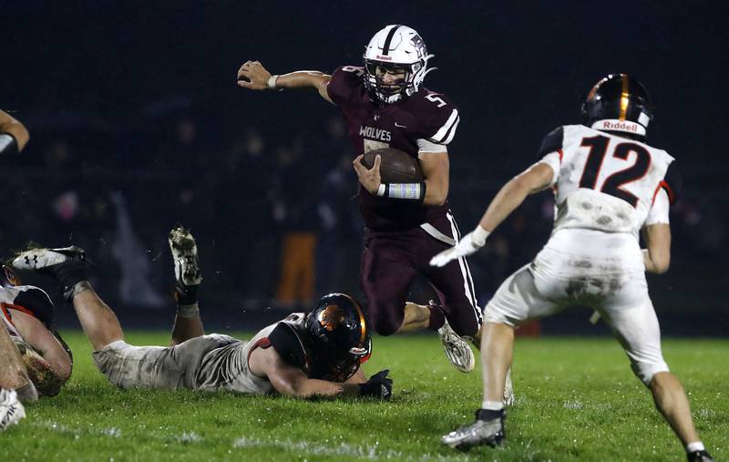 Prairie Ridge's Joseph Vanderwiel runs the ball between Crystal Lake Central's Nick Kozlowski (left) and Rene Gaunaurd during a Fox Valley Conference football game on Friday, Oct. 13, 2023, at Prairie Ridge High School in Crystal Lake.