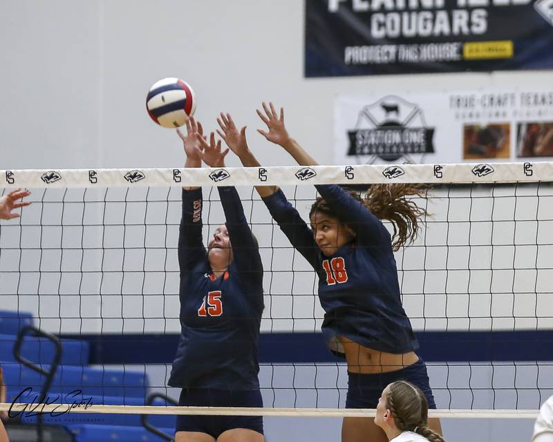 Oswego's Maya Norlin (18) and Kimberly Reichard (15) converge for a block attempt during Class 4A Regional Final volleyball match between Neuqua Valley at Oswego. Oct 30, 2025 in Plainfield.