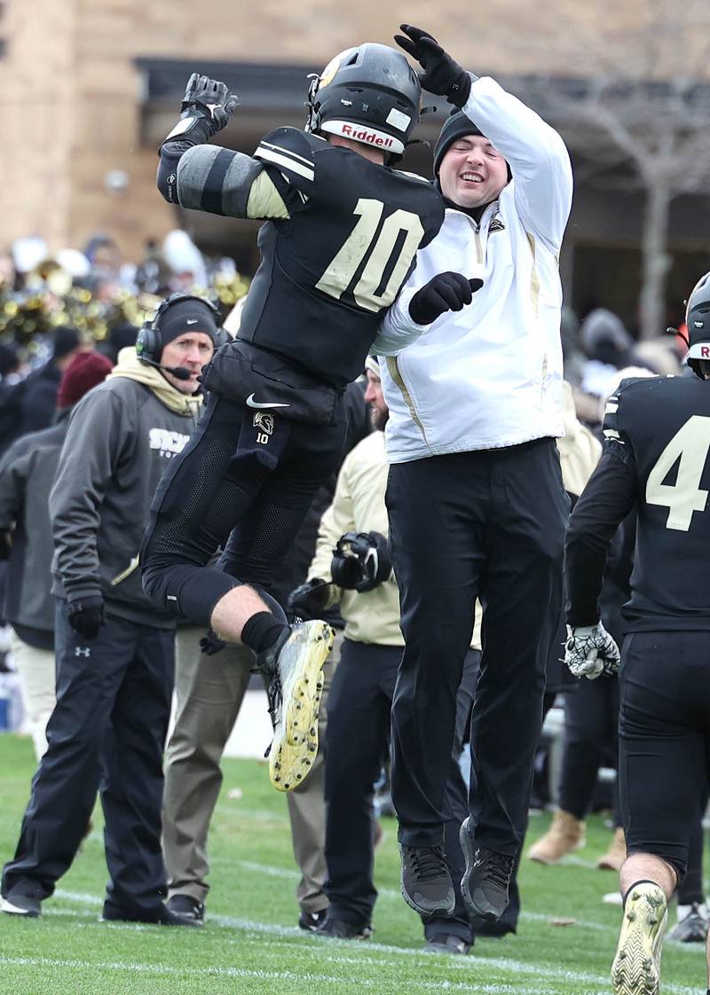 Sycamore's Zack Crawford (left) celebrates on the sidelines after he scored a touchdown during their Class 5A state playoff game against Sterling Saturday, Nov. 12, 2022, at Sycamore High School.