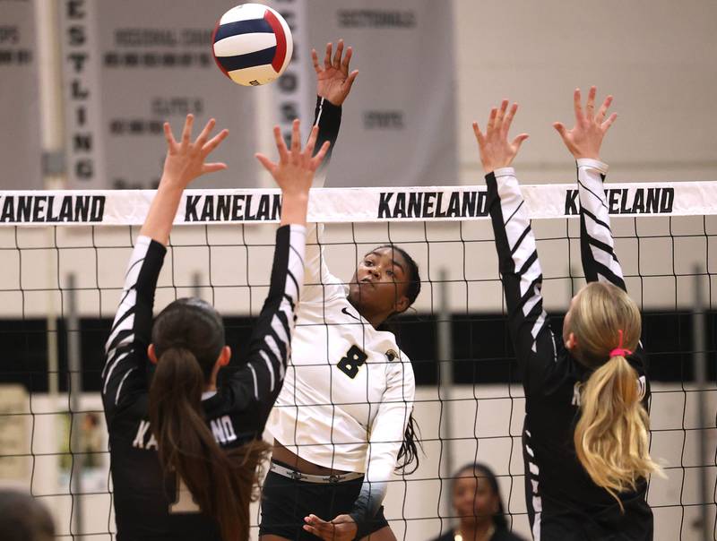 Sycamore's Khiara Thomas spikes the ball by two Kaneland blockers during their match Tuesday, Sept. 30, 2025, at Kaneland High School in Maple Park.