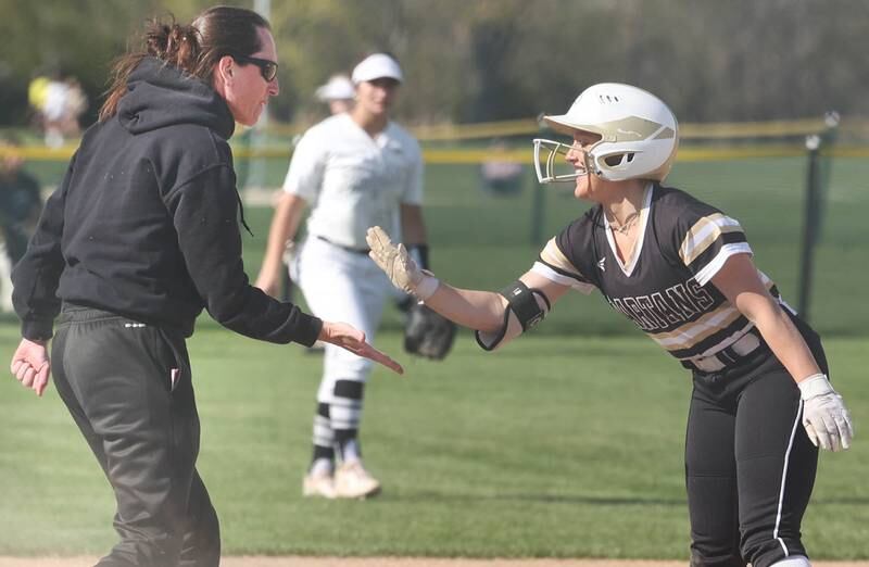 Sycamore's Addison McLaughlin is congratulated by head coach Jill Carpenter after hitting a triple Friday, April 28, 2023, during their game against Kaneland at Sycamore High School.