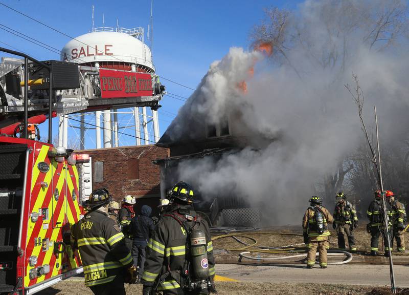 Flames pour out of the roof of a fully engulfed house fire in the 800 block of Bucklin Street on Friday, Jan. 23, 2026 in La Salle.