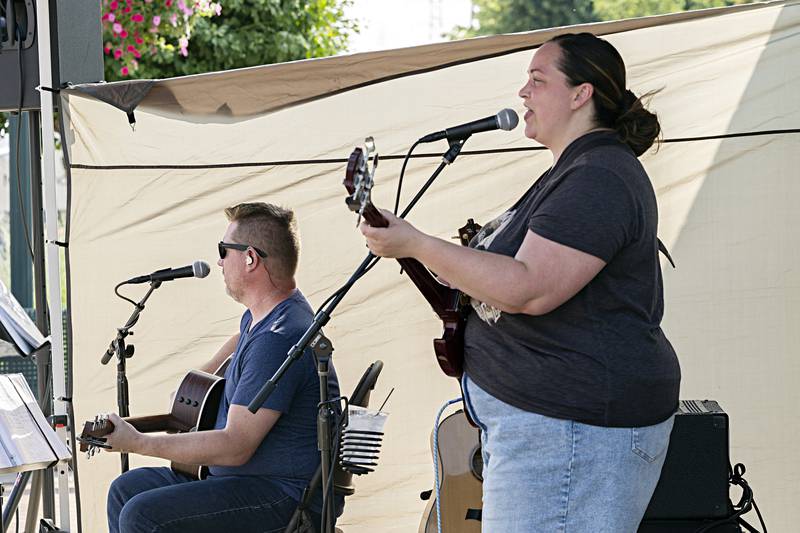 David Coffey and Shannon Espinosa, who make up the duo of Coffey and Espinosa, play Dixon’s City Market on  Wednesday, June 21, 2023. A steamy day didn’t stop the crowds from enjoying the weekly market.