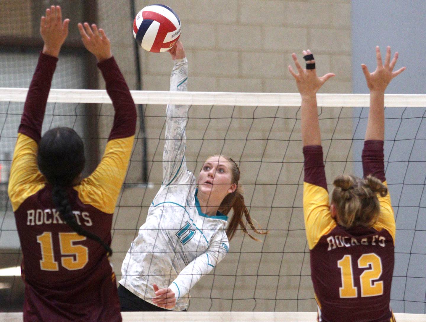 Woodstock North’s Alexis Hansen, center, sends the ball over the net against Richmond-Burton in varsity volleyball at Woodstock Monday night.