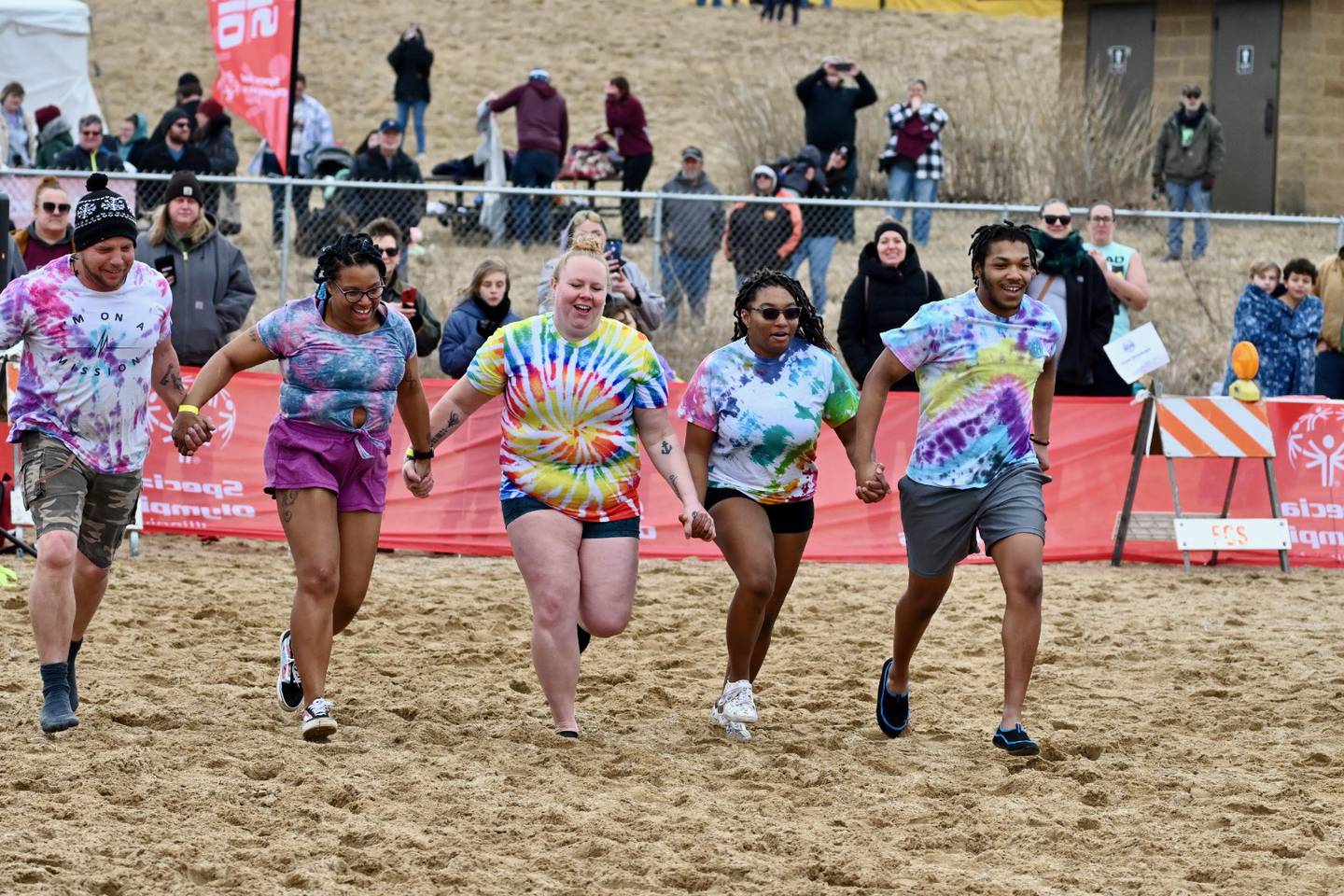 A team of five individuals run toward cold water during a polar plunge fundraiser in this photo provided by Special Olympics Illinois, a nonprofit organization that benefits from the winter time fundraisers.