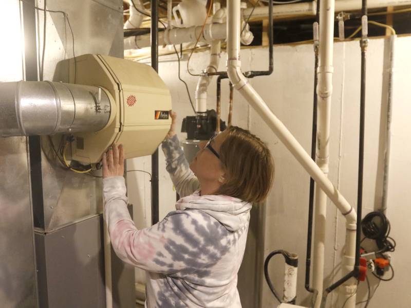 Stephanie Tesmer checks a water filter in her home on Monday, March 27, 2023. Some residents of the Eastwood Manor subdivision in McHenry are upset with the quality of water from the private water company that serves them.