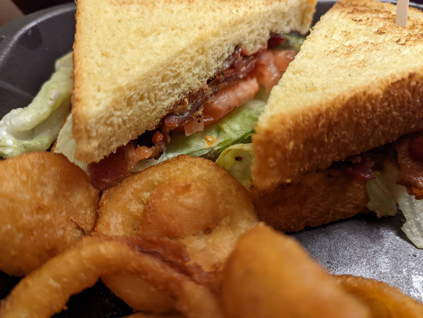 Pictured is the BLT club sandwich deluxe with a side order of onion rings from Happy Place Cafe in Shorewood. The BLT club featured crisp slices of bacon and lettuce as well as tomatoe between two slices of toasted bread,