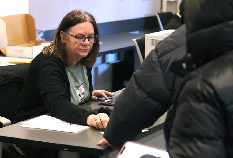 Election judge Terrilynn Morris checks in voters for the primary election Tuesday, March 17, 2026, at the DeKalb County Administration Building in Sycamore.