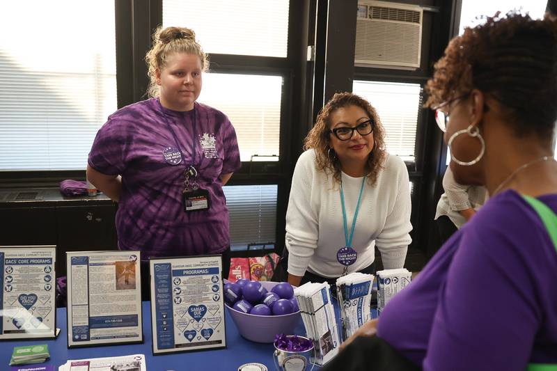 Abby Kobal, left, and Johanna Vargas, of Guardian Angels Community Service, talk with an event goer at the Take Back the Night event at Hufford Junior High on Thursday, Oct. 5, 2023 in Joliet.