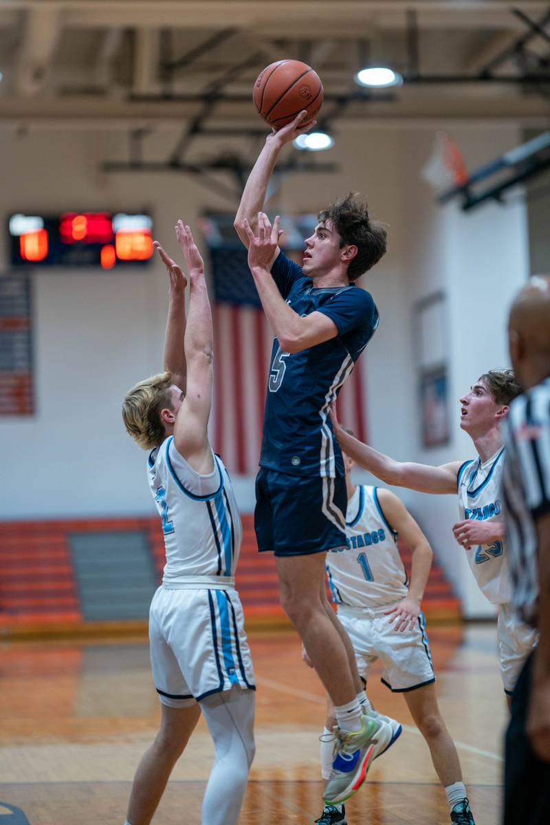 Oswego East's Mason Blanco (5) shoots the ball in the post over Downers Grove South's Will Potter (2) during the hoops for healing basketball tournament at Naperville North High School on Monday, Nov 21, 2022.