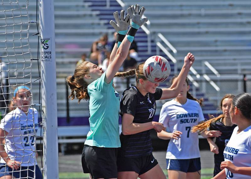 Downers Grove South goalkeeper Delia Whaley blocks a header by Downers Grove North’s Grace Gagnon during a game on May 10, 2025 at Downers Grove North High School in Downers Grove .