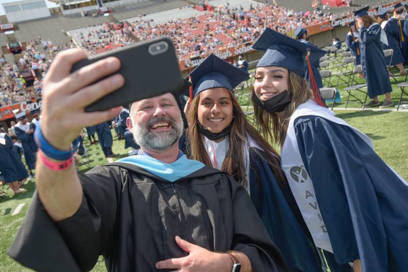 Oswego High School Library Director Drew Mundsinger takes a selfie with Adilene Santacruze and Kiara Barragan before the graduation ceremony at NIU’s Huskie Stadium on Saturday, May 22, 2021 in DeKalb.