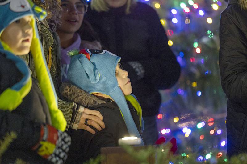 Enzo Reyes gazes up at the tree after hitting the button to fire up the lights Friday, Dec. 5, 2025, in Dixon.
