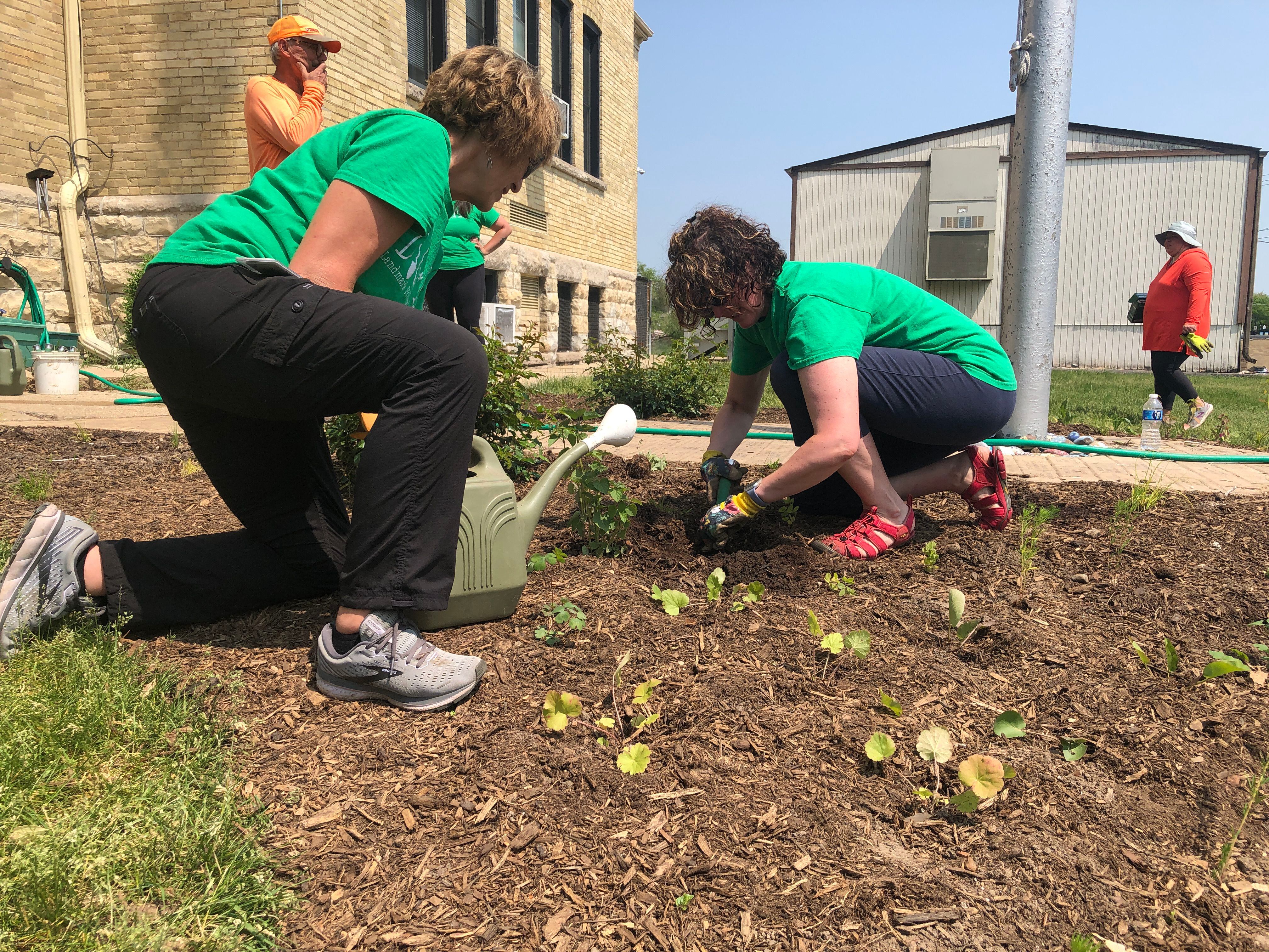 Principal Margaret Carey (left) and teacher Jessica Hodge help to water the newly planted pollinator garden May 23, 2023, at Landmark School, 3614 Waukegan Road, McHenry.