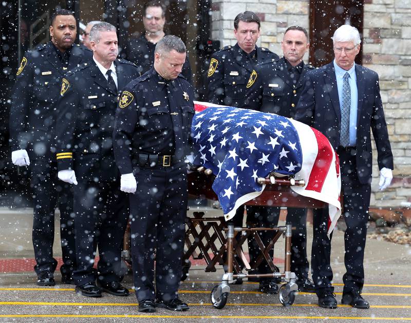 The casket of former DeKalb County Sheriff Roger Scott is brought out of the church by a detail of law enforcement officers Friday, March 7, 2025, following his memorial service at Bethany Road Bible Church in DeKalb. Scott, who was the county sheriff for 36 years, died on February 23 at the age of 78.