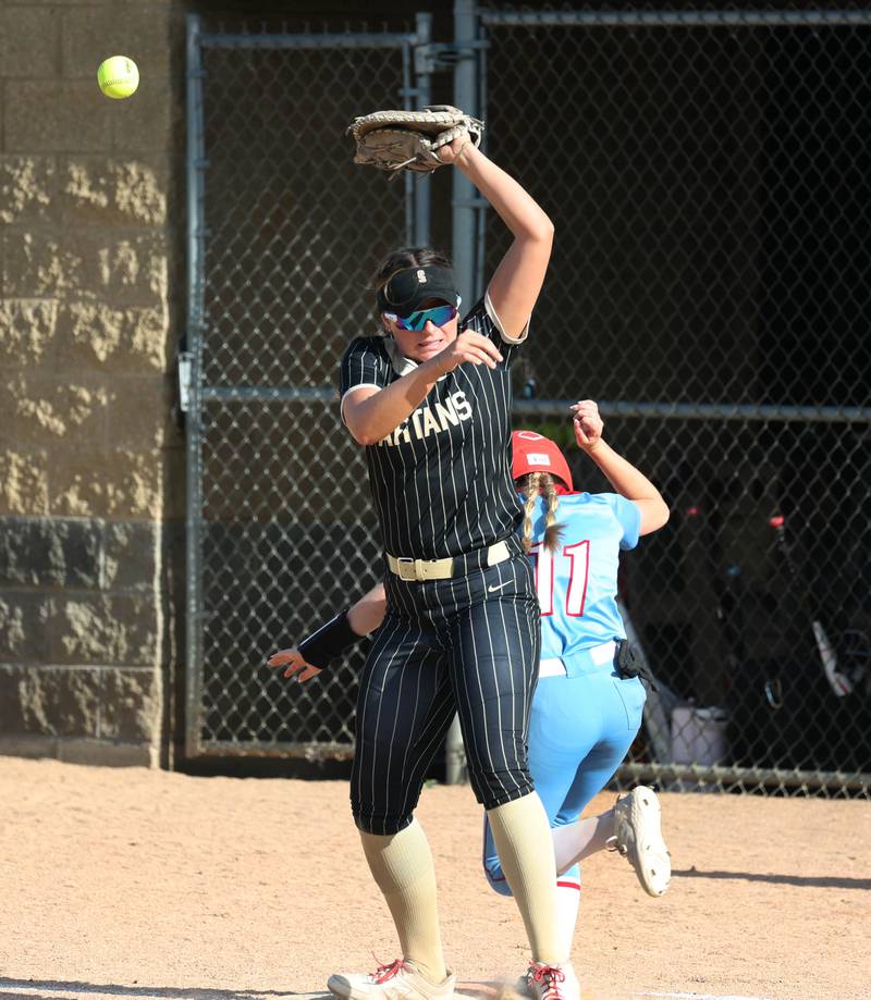 Ottawa's Rylee Harsted is safe at first base as Sycamore's Kaitlyn Williams can’t catch the high throw Monday, May 12, 2025, during their game at Sycamore High School.