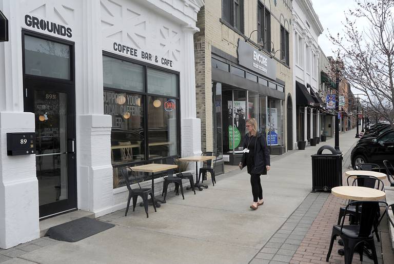 A woman walks past the outdoor seating that has sprung up outside Grounds Coffee Bar and Cafe at 89 N. Williams St. in downtown Crystal Lake and other spots around town in preparation of warmer weather and outdoor dining.
