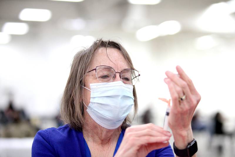 Donna Plonczynski of Geneva, a volunteer with the Kane County Medical Reserve Corps, fills a syringe with the Moderna COVID-19 vaccine at the county's first COVID-19 mass vaccination site on Friday, March 19, 2021. The site is located in the former Sam's Club building at 501 N. Randall Road in Batavia. It will be open six days a week and is expected to serve 18,000 people per week to start.