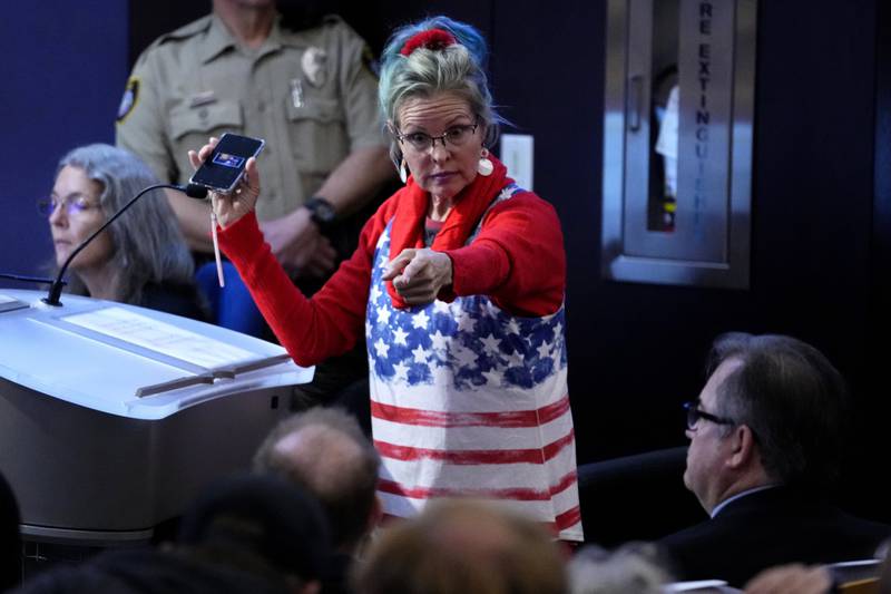 FILE - A woman points at Maricopa County Recorder Stephen Richer during the Maricopa County Board of Supervisors general election canvass meeting, Nov. 28, 2022, in Phoenix. Dominion Voting Systems has been ensnared in a web of conspiracy theories that have undermined public confidence in U.S. elections among conservative voters. (AP Photo/Matt York, File)