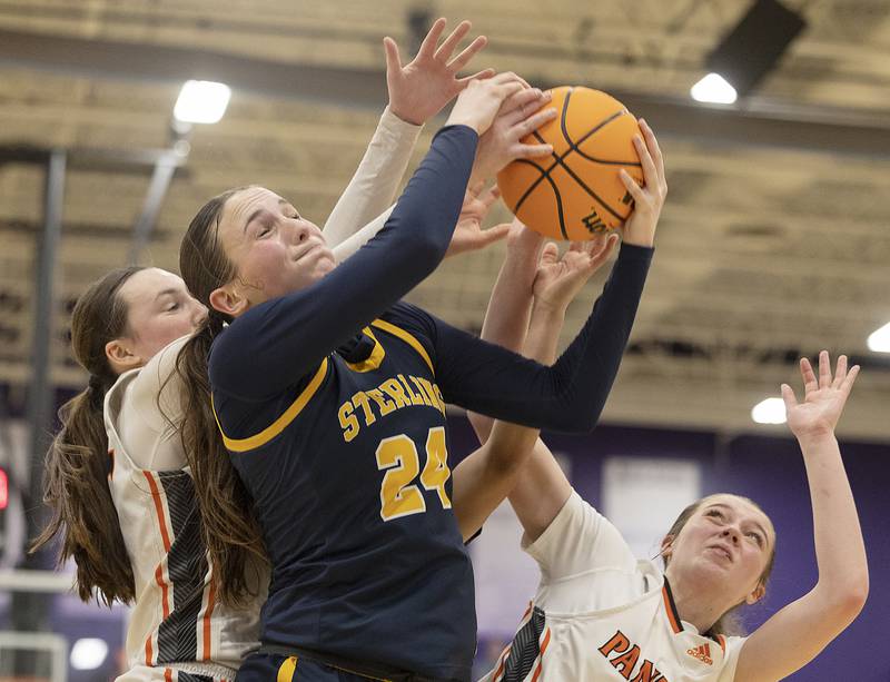 Sterling’s Madison Austin fights for a rebound against a pair of Washington players Monday, March 3, 2025, during the 3A Supersectional at Rochelle High School.