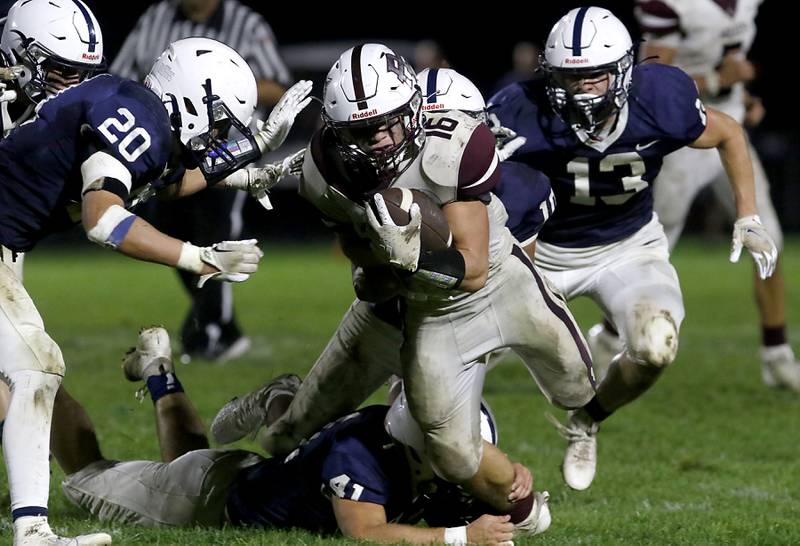 Prairie Ridge's Dominic Creatore fights for extra yards as Cary-Grove's Connor Anderson, (left) Ian Moran, (center) and Corey Adams, (right) try to bring Creatore down during a Fox Valley Conference football game on Friday, Sept. 22, 2023, at Cary-Grove High School in Cary.
