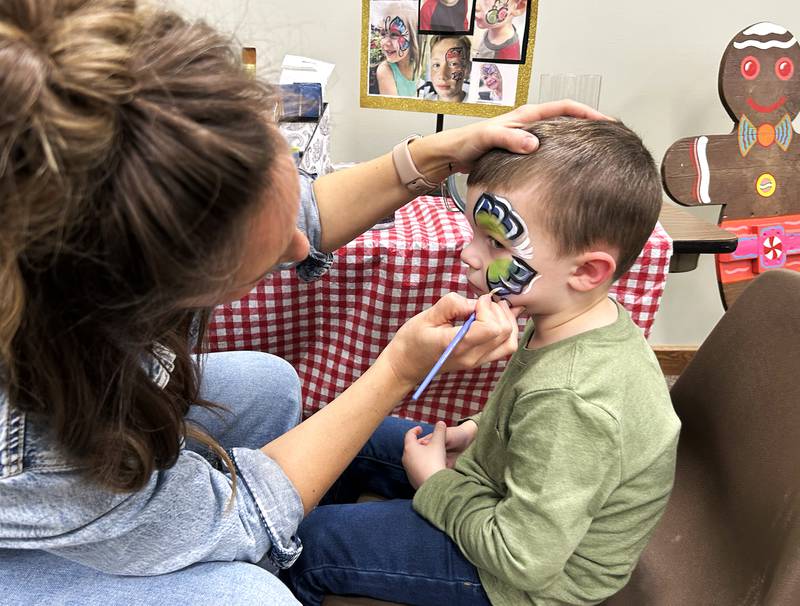 Will Ellingwood, 3, of Byron, gets a butterfly painted on his face at Oregon Candlelight Walk's Kid's Winter Carnival at the United Methodist Church on Saturday, Dec. 6, 2025.