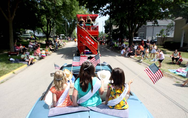 Participants from the Little Miss Kiwanis wave from the back of a classic Cadillac during the McHenry Fiesta Days Parade along Main Street on Sunday.