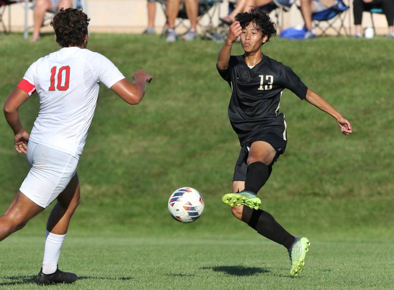 Sycamore's Chandler Gatbunton kicks the ball by La Salle-Peru's Giovanni Garcia during their game Wednesday, Sept. 7, 2022, at Sycamore High School.