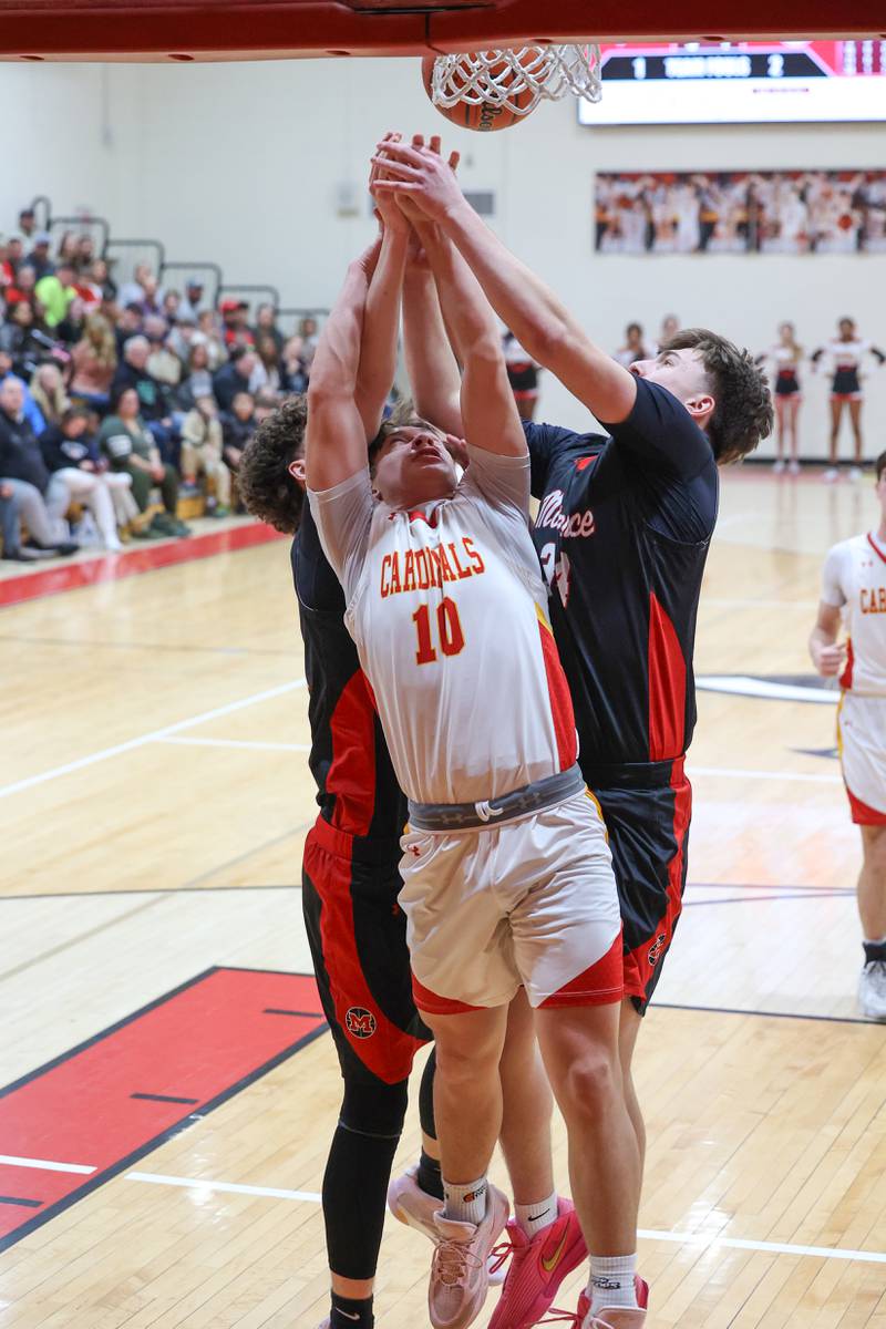 St. Anne's Grant Pomaranski reaches for a rebound against two Momence players during St. Anne's 64-43 victory in the River Valley Conference semifinals on Tuesday, Feb. 10, 2026.