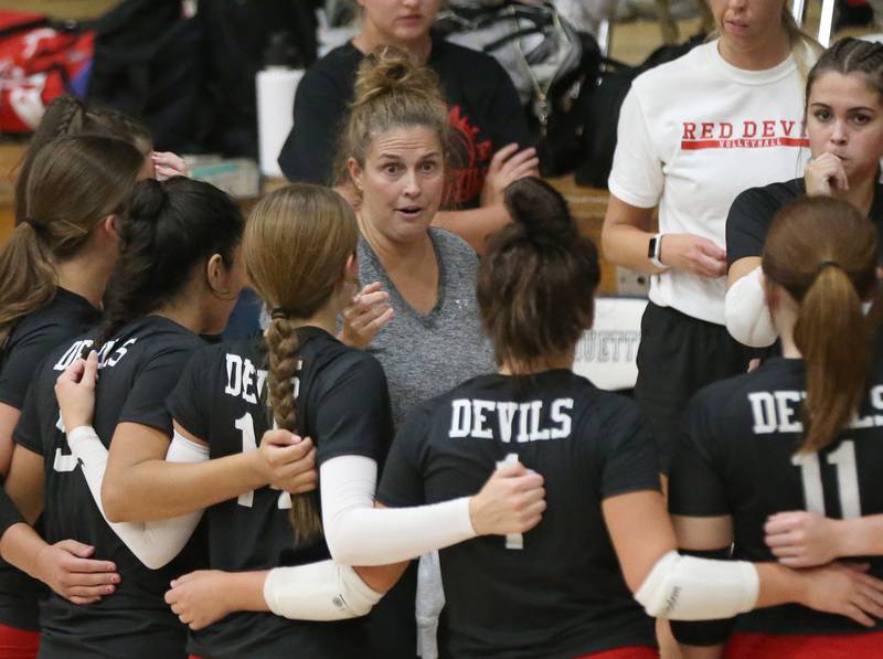 Hall head volleyball coach Carolyn Foster huddles with her team during a timeout while facing Marquette on Monday, Sept. 25, 2023 at Bader Gym.
