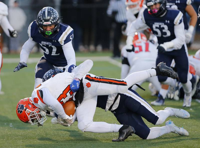 Byron's Carsen Behn (33) is tackled by KJ Parker (14) during the Class 3A varsity football semi-final playoff game between Byron High School and IC Catholic Prep on Saturday, Nov. 19, 2022 in Elmhurst, IL.