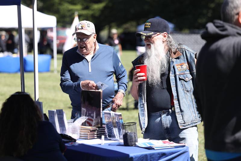 Army veterans Everett Johnson, left, and Dennis Ostrowski check out the Choose VA Health Care table at the 11th Annual Operation Firm Handshake Veteran’s Picnic on Saturday, Sept. 7, 2024 in Coal City.