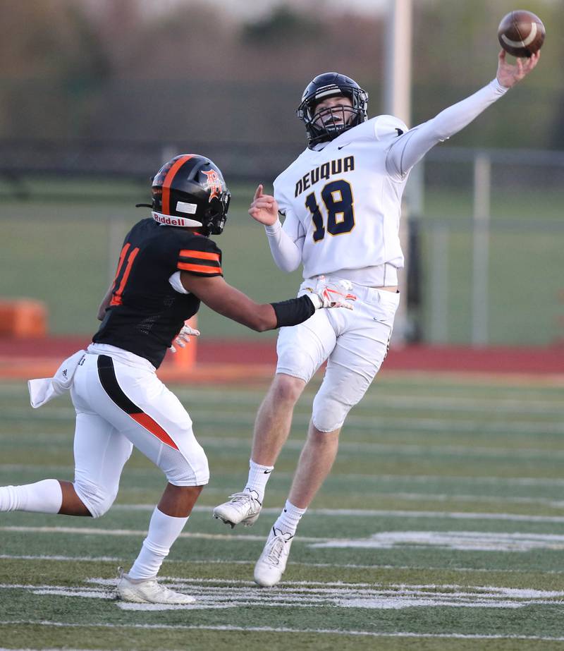 Neuqua Valley quarterback Mark Mennecke gets rid of the ball just ahead of the rush by DeKalb's Ethan Cano during their game Friday night at DeKalb High School.