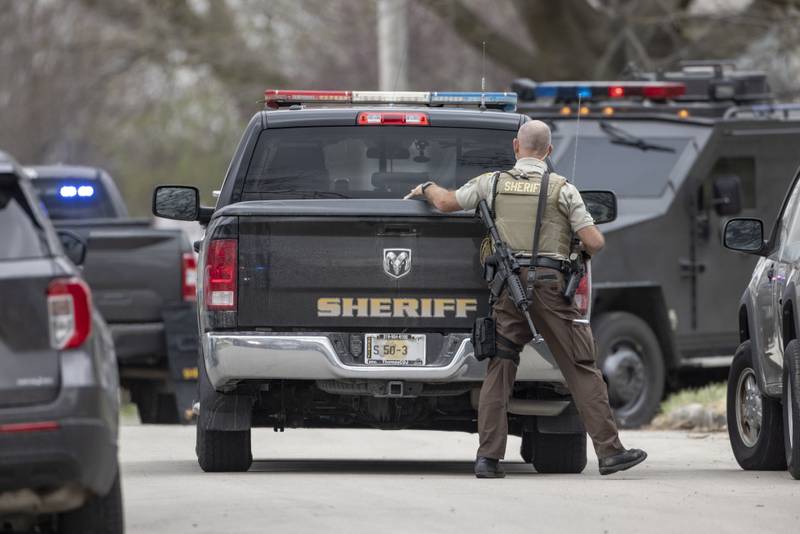 A police officer assesses the situation from behind his truck outside of a two-story apartment building on the corner of Seventh and Charters on Sunday, March 30, 2025 in La Salle. A barricaded armed subject fired shots at officers. Police from across the Illinois Valley assisted in the incident.