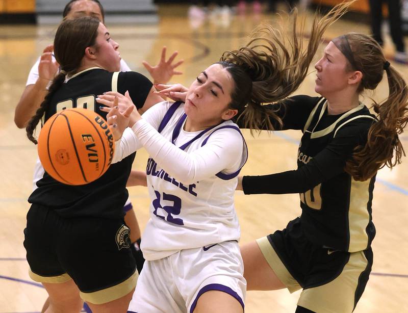 Rochelle’s Gianna Olguin tries to corral a rebound in front of Sycamore's Callie Countryman (left) and Cortni Kruizenga Friday, Dec. 5, 2025, during their game at Rochelle High School.