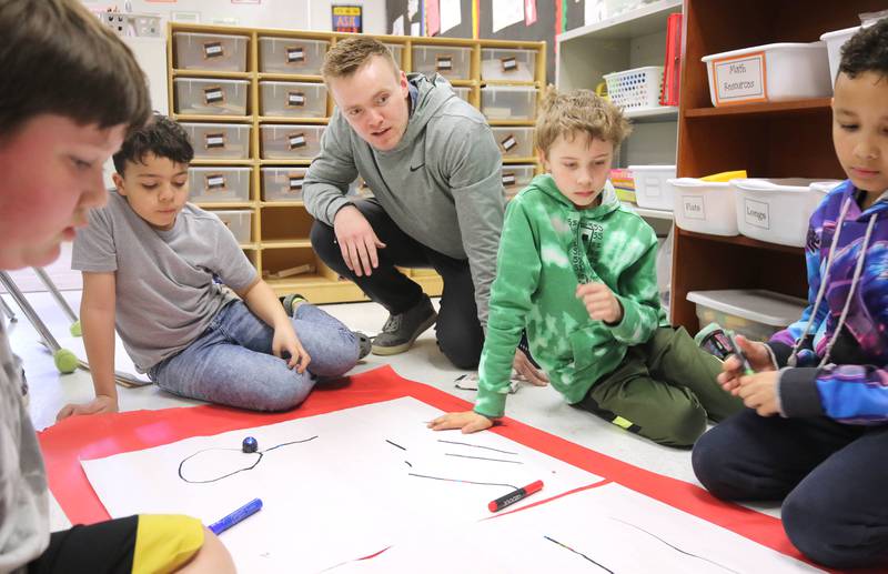 Jacob Winters, fourth grade teacher at South Prairie Elementary School, works with students during a robotics lesson Wednesday, April 6, 2023, at the school in Sycamore.