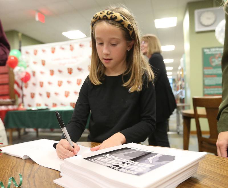 Author Reese Carney 8, of Utica signs copies of her book titled "Reeses Fantastic Surgery Adventure" on Monday, Nov. 6, 2023 at La Salle-Peru Township High School.