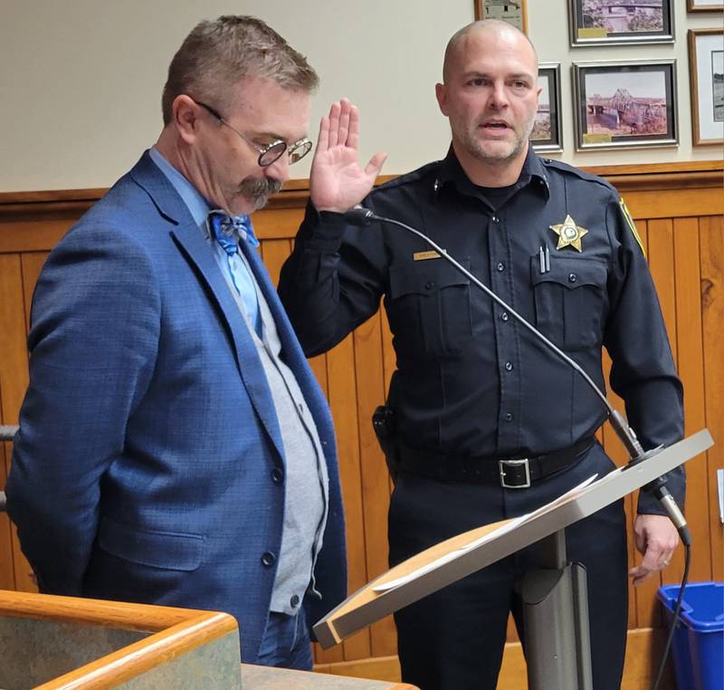 New Ottawa Police Chief Mike Cheatham (right) repeats the oath given him by Mayor Robb Hasty at Tuesday's Ottawa City Council meeting.