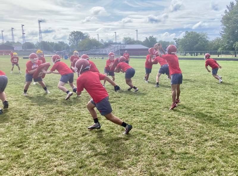 The Red Devils work on a play during the first day of practice Monday morning. They will open the season Friday, Aug. 25 at Orion.