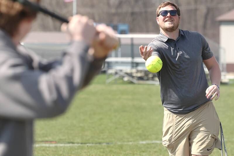 Griffin McNeal, Genoa-Kingston High School physical education teacher, pitches to students in his class Thursday, April 13, 2023, as they get outside to play some softball.