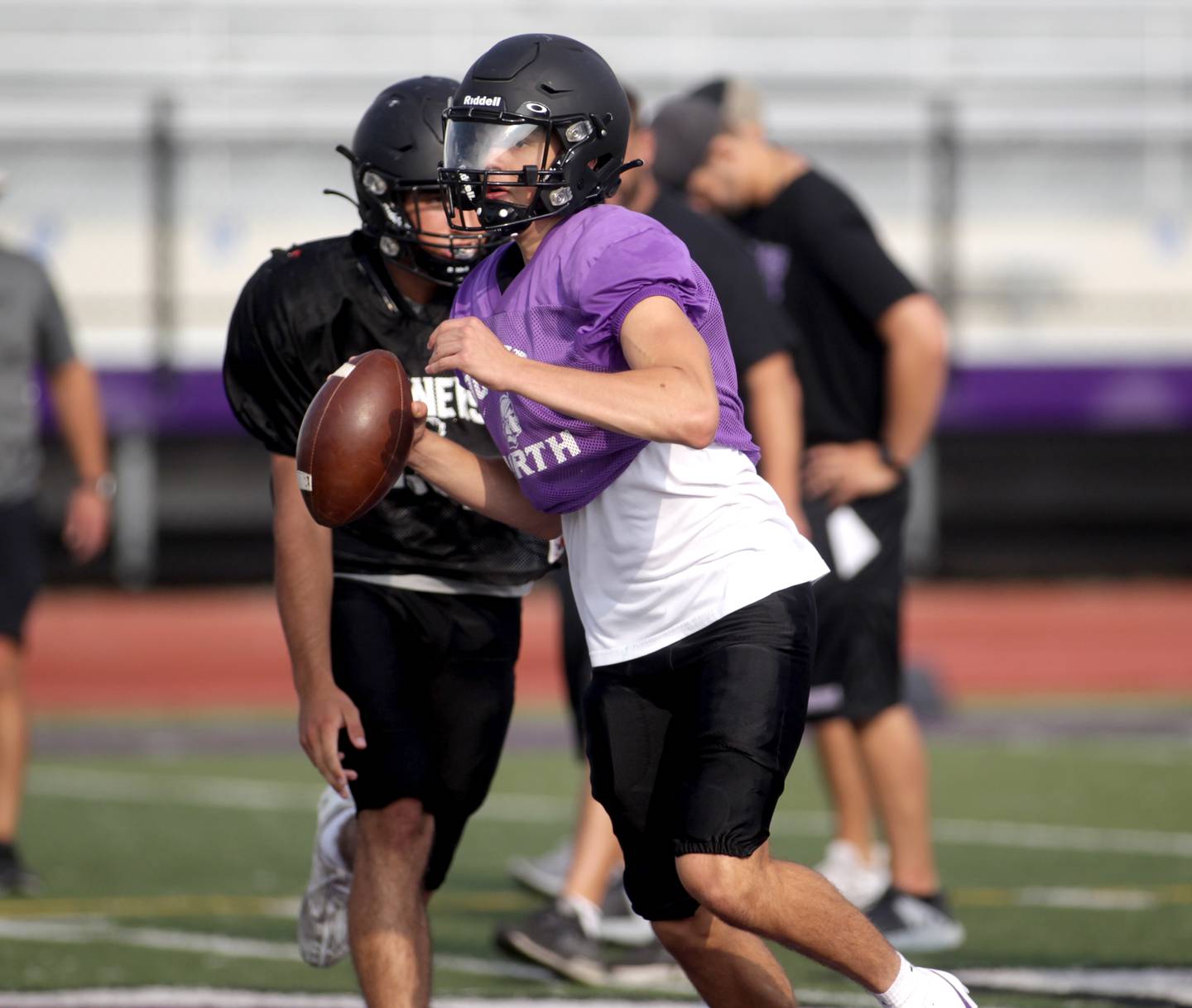 Downers Grove North quarterback Owen Lansu keeps the ball during a practice at the school on Tuesday, Aug. 15, 2023.