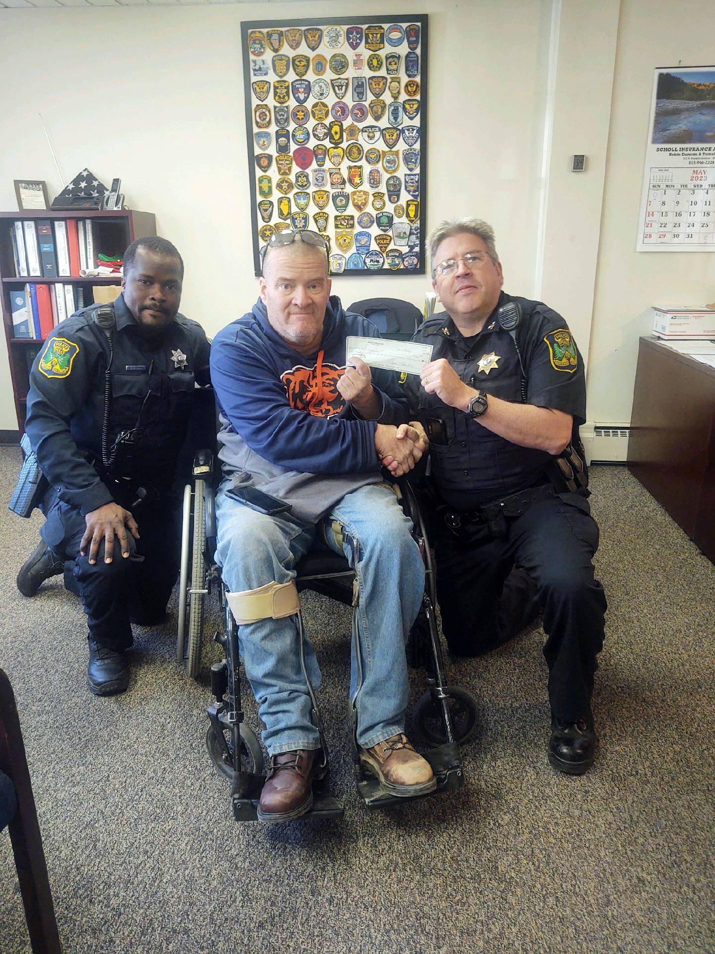 Polo Lions Club member Jeff Short, center, hands a $500 donation to Polo Police Chief Troy Randall, right, on May 2, 2023. To Short's right is Officer Geraurd Zinsou.