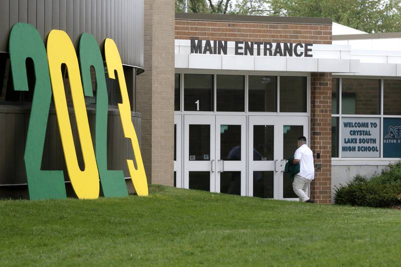 A graduates walks into the school in front of a giant 2023 sign Saturday, May 13, 2023, before the graduation ceremony for class of 2023 at Crystal Lake South High School in Crystal Lake.